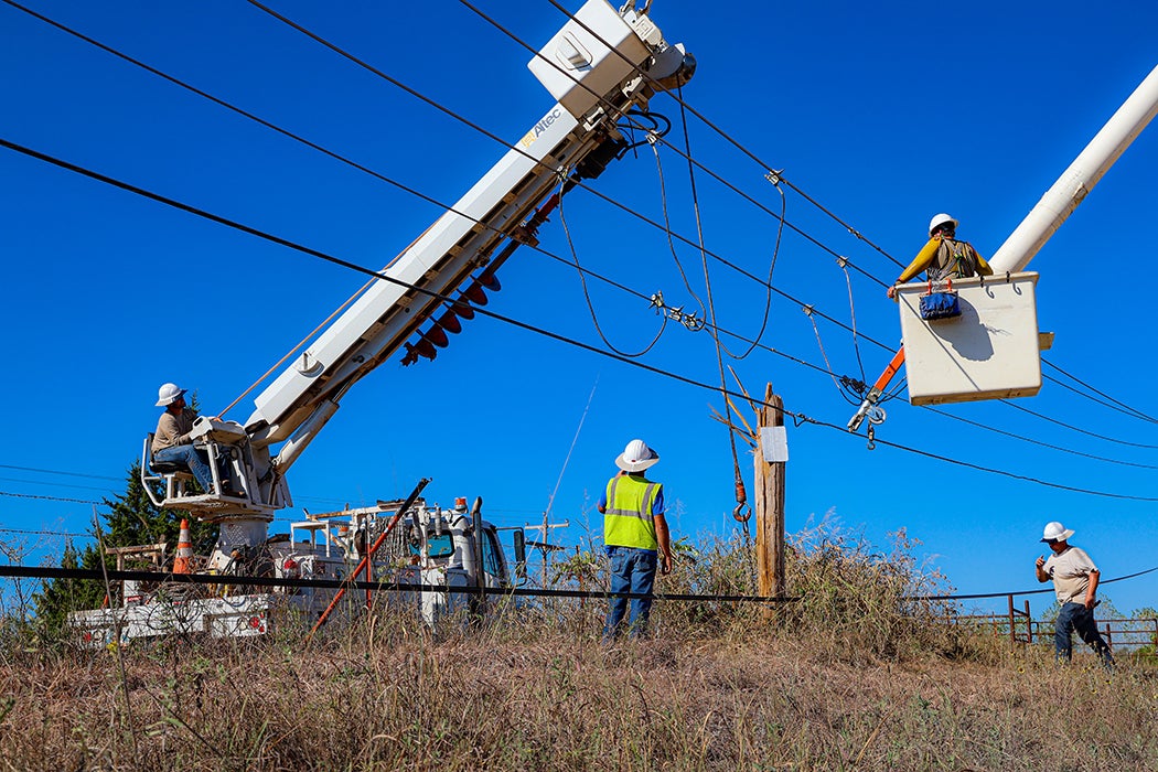 Crews work to restore a broke pole. 