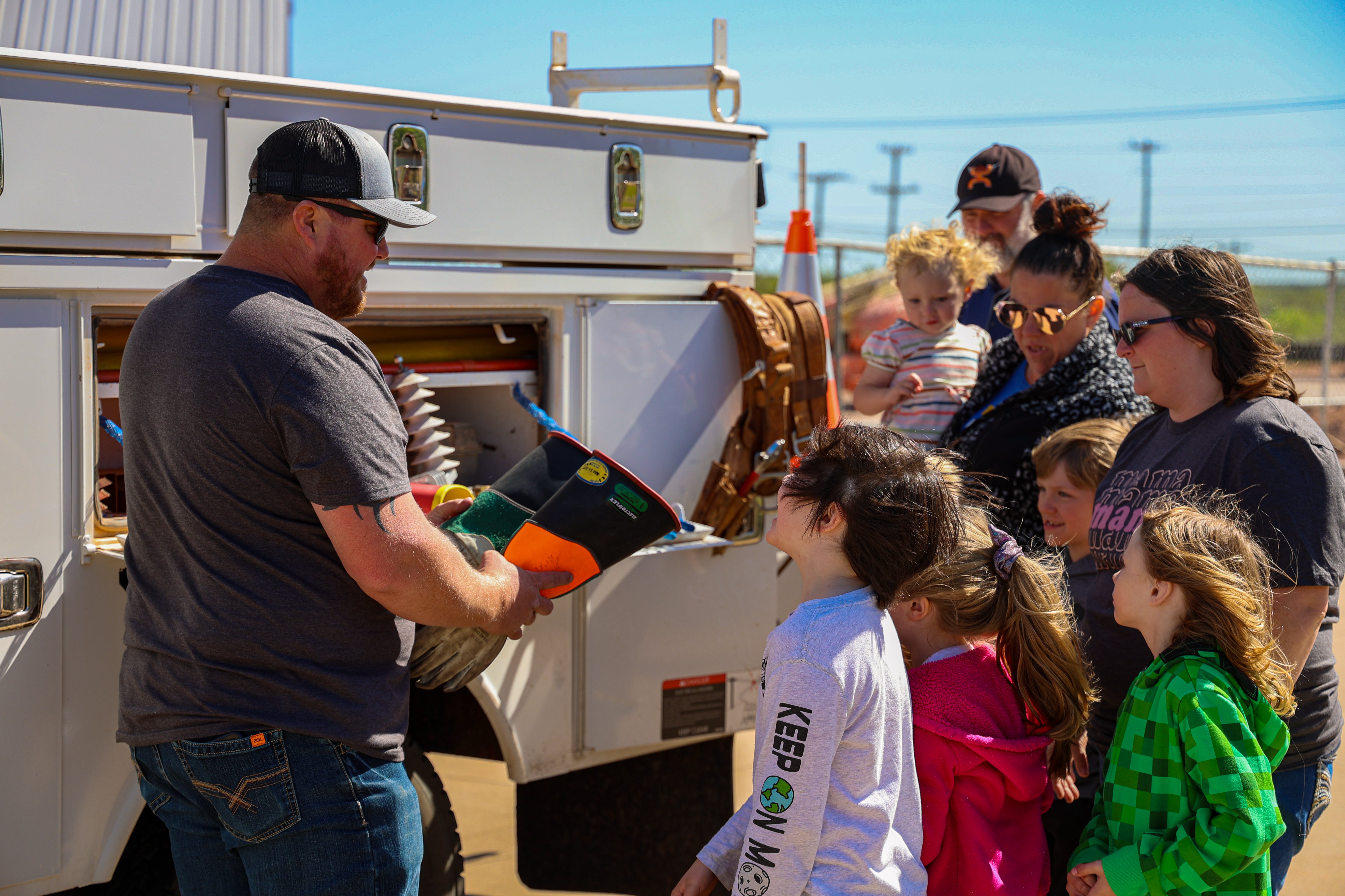 Children learning about lineman tools from a lineman at Co-op Kids day. 
