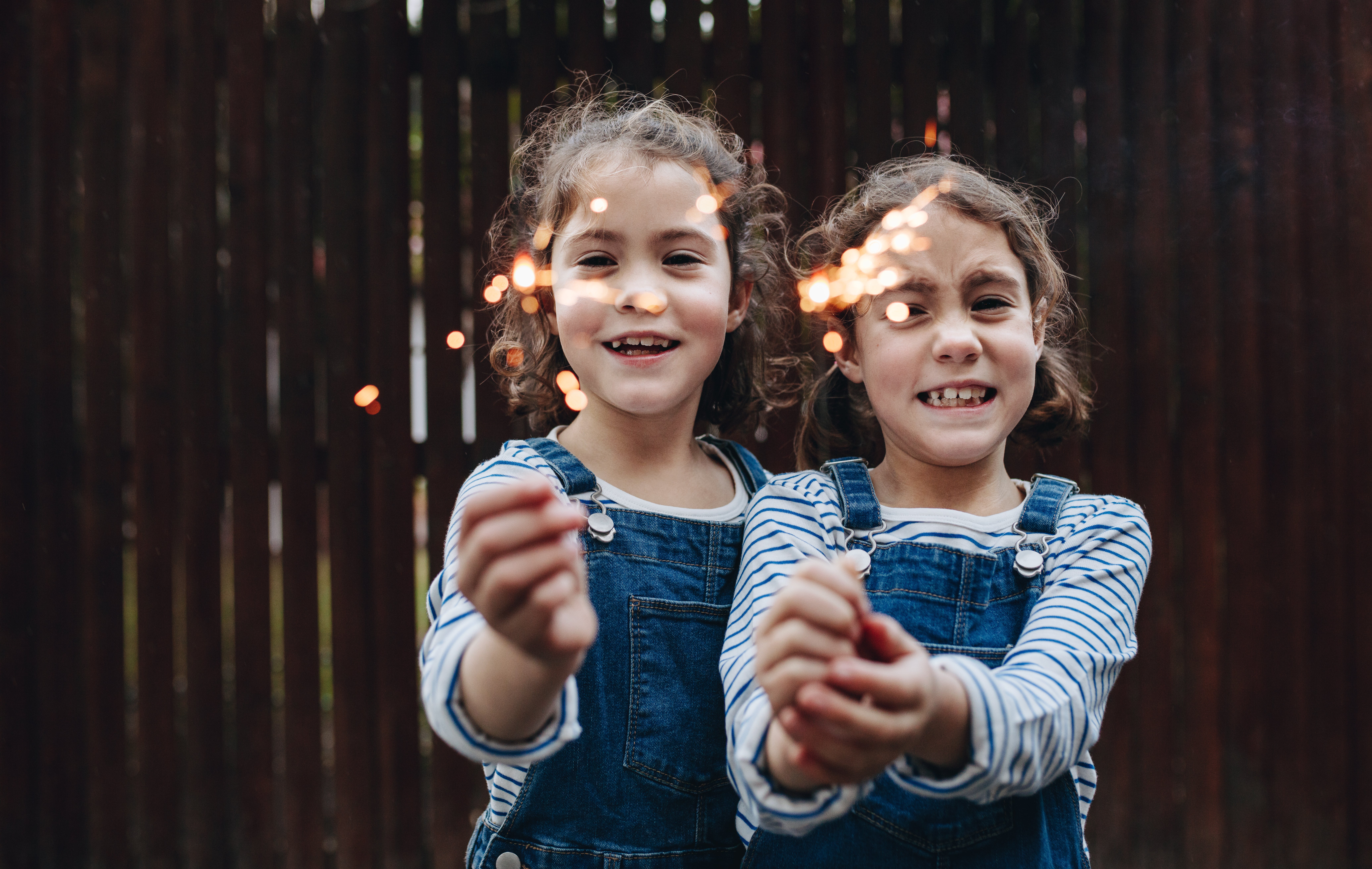 Stock image of two girls playing with fireworks. 